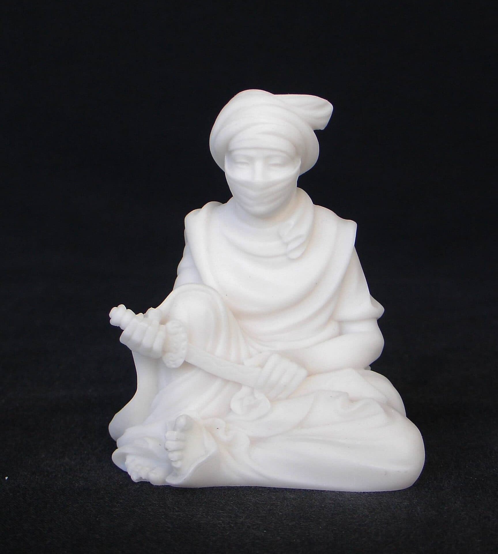 Arab man statue holding knife sitting down