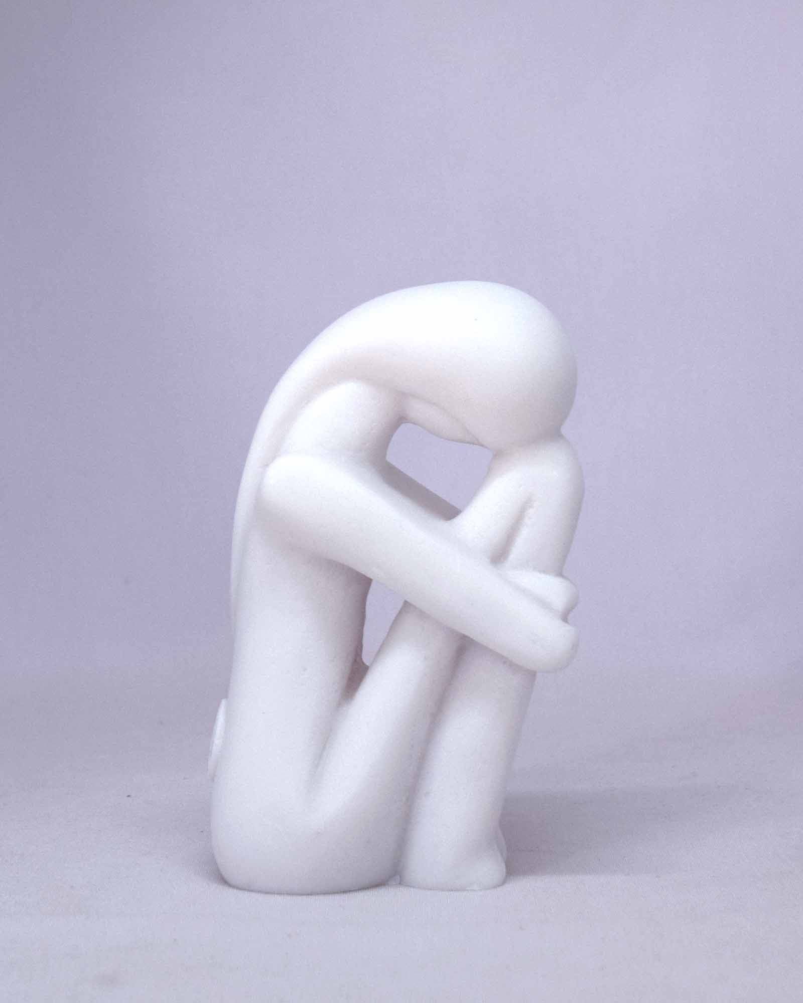 Woman hugging her feet in Cycladic art
